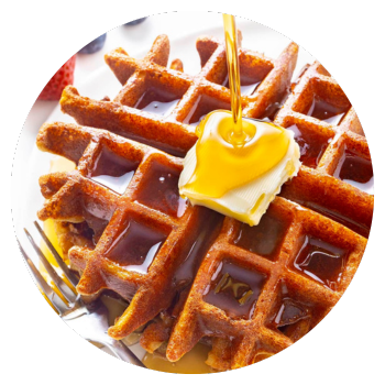 A waffle on a plate with butter and keto maple syrup.