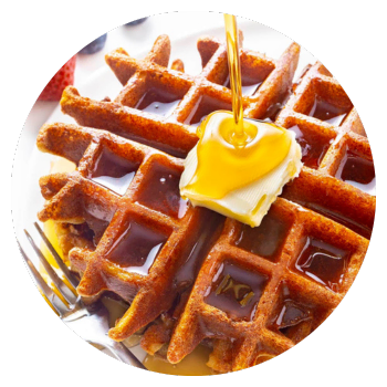 A waffle on a plate with butter and keto maple syrup.