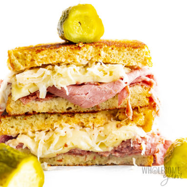 Keto reuben sandwich halves stacked on top of each other and garnished with pickles