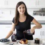 Maya Pouring Wholesome Yum Sugar Free Blueberry Syrup on Pancakes.