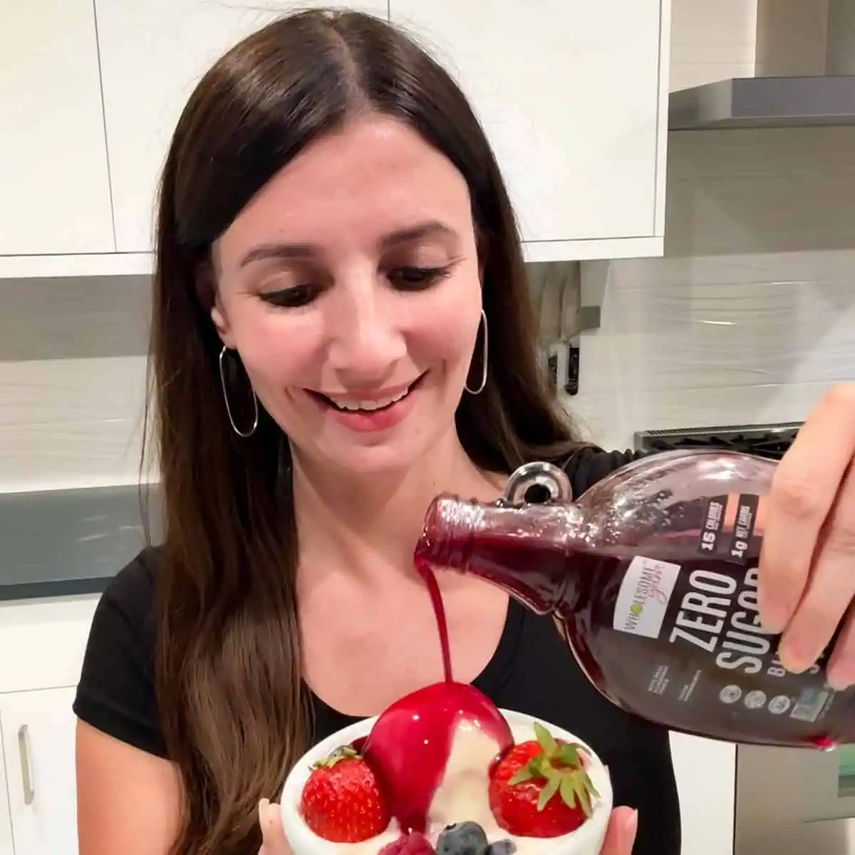Maya Pouring Wholesome Yum Sugar Free Blueberry Syrup on Ice Cream.
