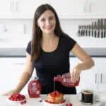 Maya Pouring Wholesome Yum Sugar Free Raspberry Syrup on Pancakes.