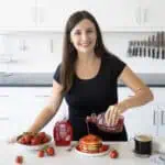 Maya Pouring Wholesome Yum Sugar Free Strawberry Syrup on Pancakes.