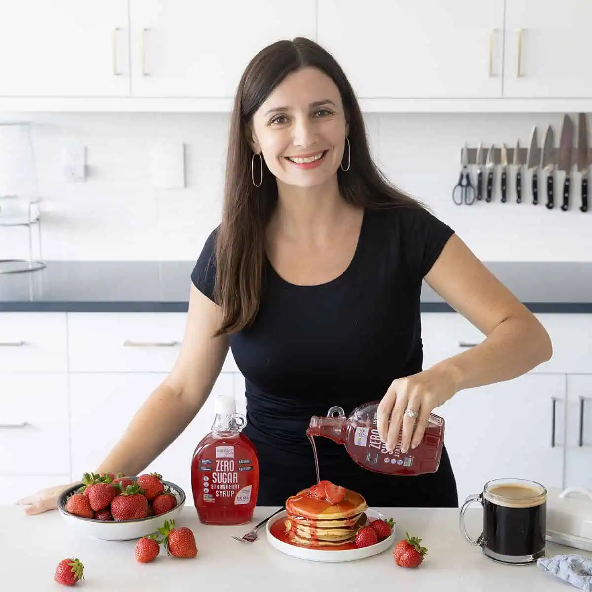 Maya Pouring Wholesome Yum Sugar Free Strawberry Syrup on Pancakes.