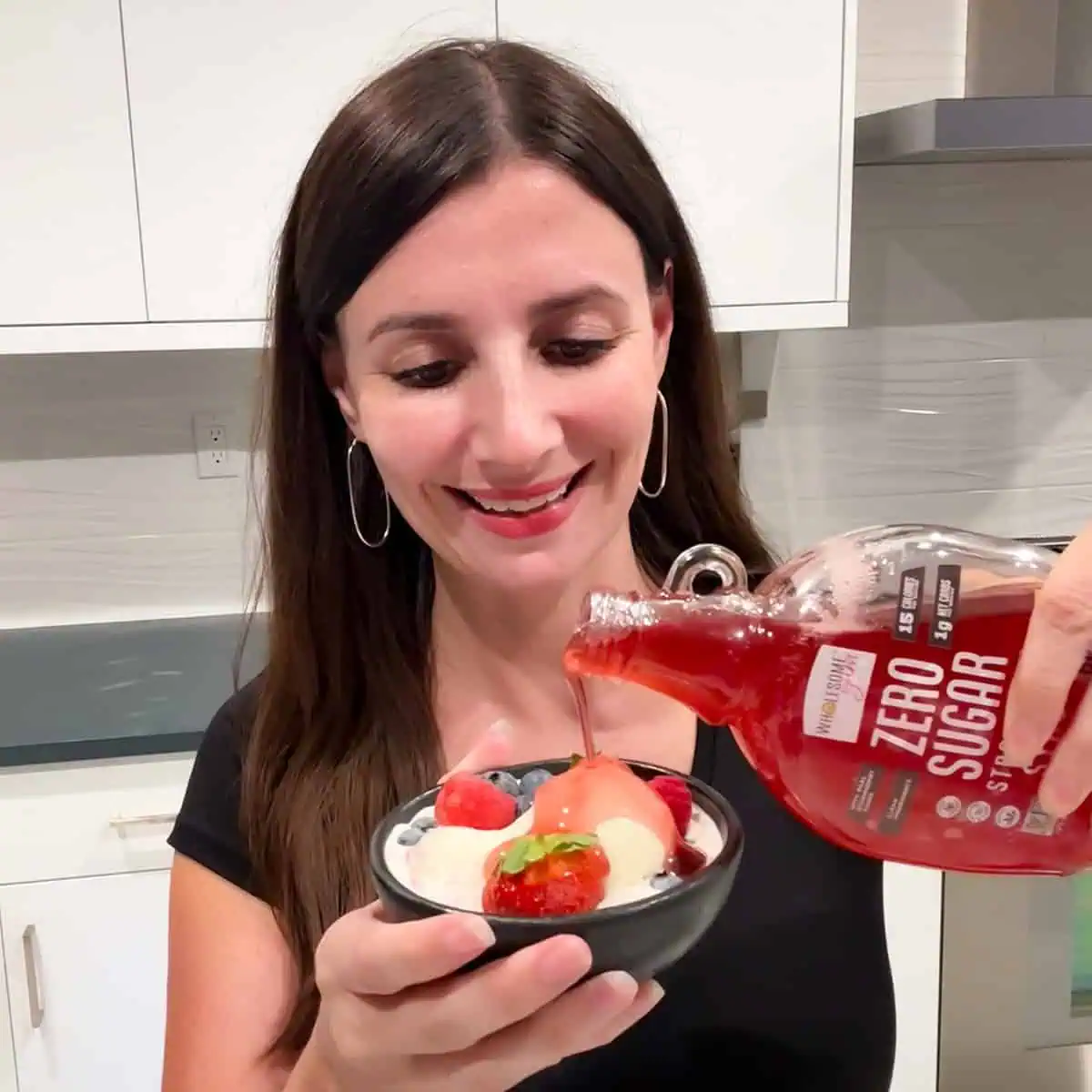 Maya Pouring Wholesome Yum Sugar Free Strawberry Syrup on Ice Cream.